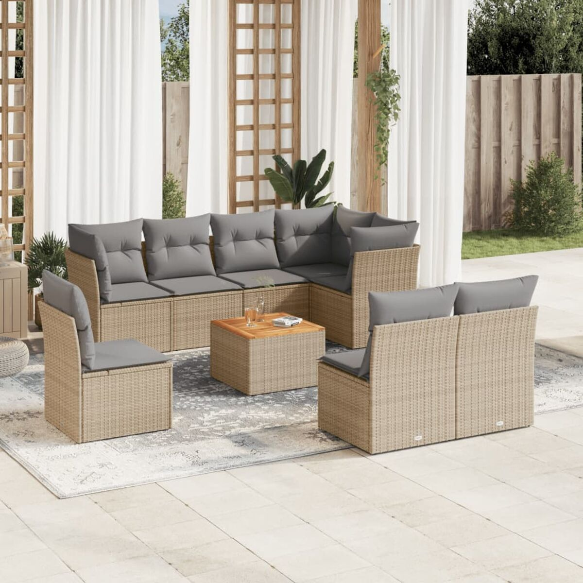 Ein Terrassenset mit einem Ecksofa, Stühlen und einem Couchtisch. Auf dem Boden liegt ein Teppich.