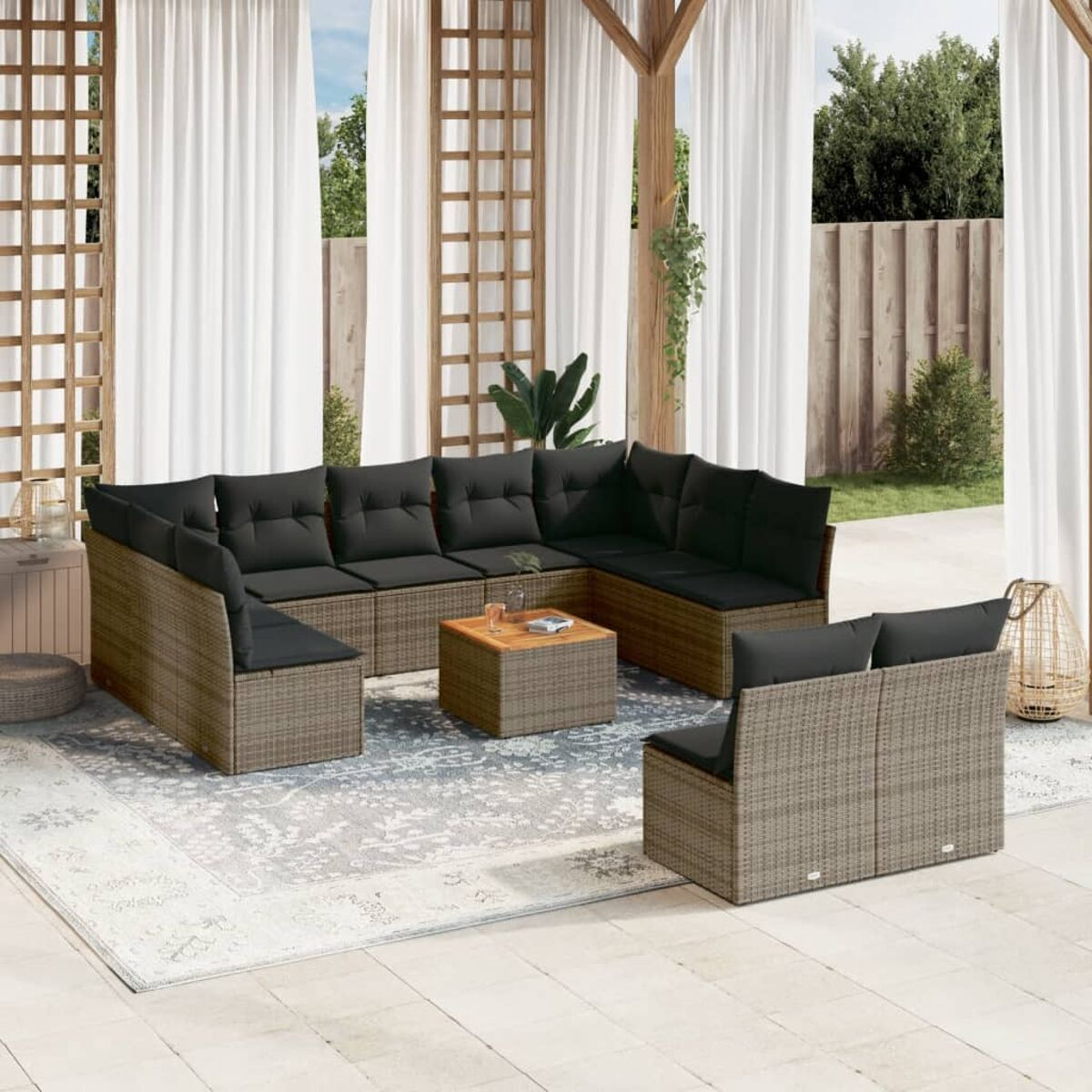 Beiges Rattan-Outdoor-Ecksofa mit schwarzen Kissen auf einer Terrasse.