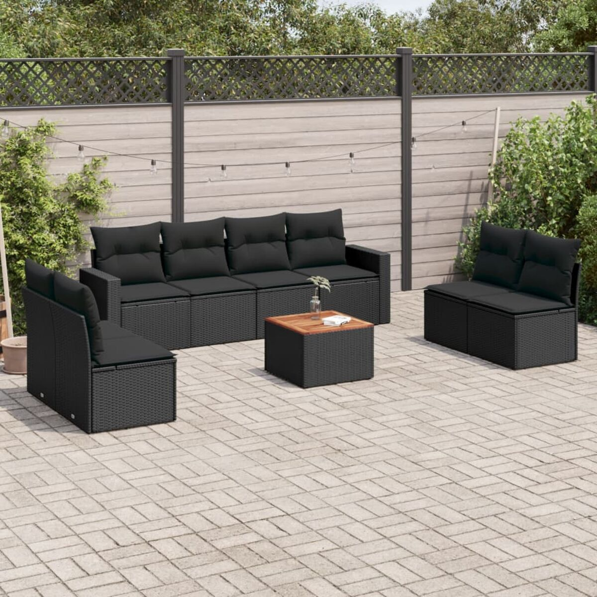 Gartenset mit Sofa, zwei Sesseln und einem Tisch. Schwarzes Korbgeflecht und Kissen.