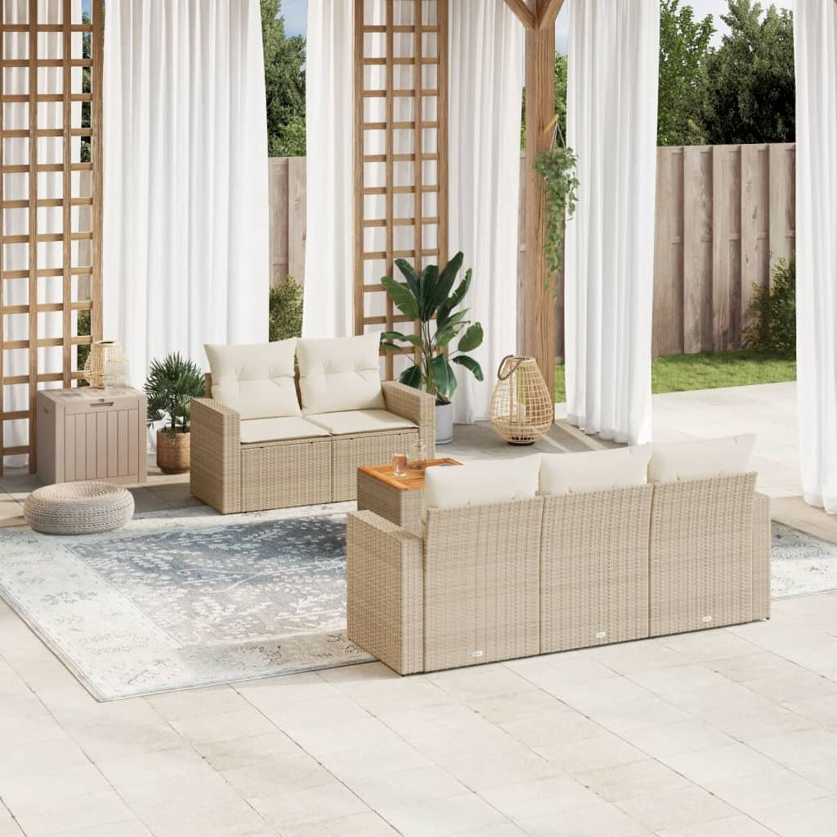 Beiges Rattan-Sofa-Set im Freien mit cremefarbenen Kissen, Teppich und Holzakzenten auf der Terrasse.