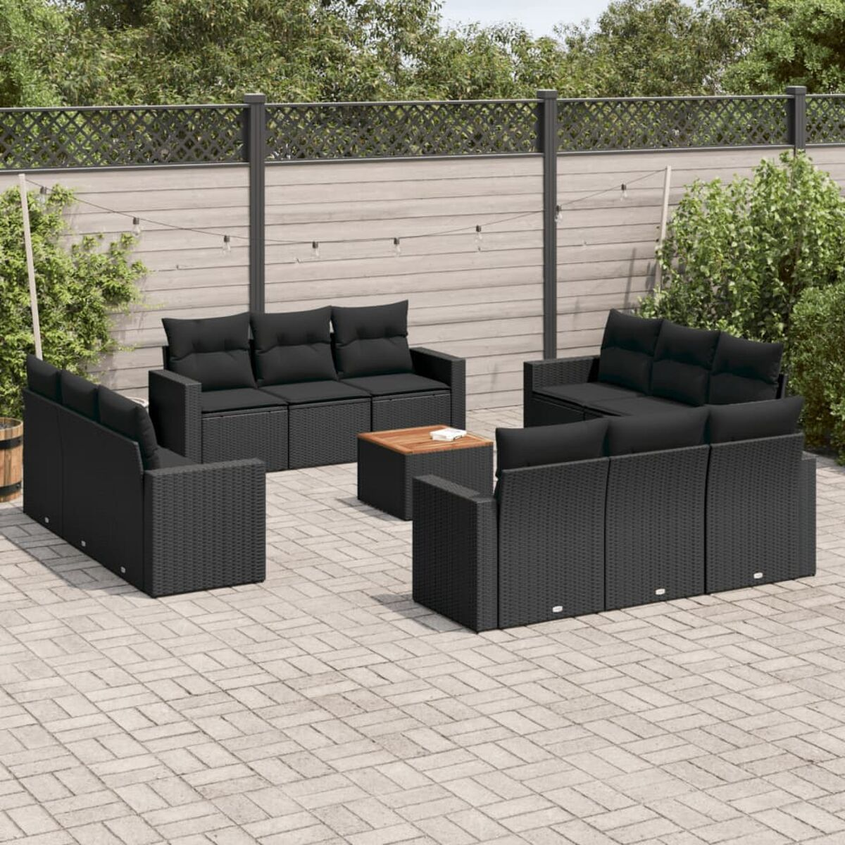 Schwarzes Outdoor-Sofa-Set aus Korbgeflecht mit schwarzen Kissen und Holztisch.
