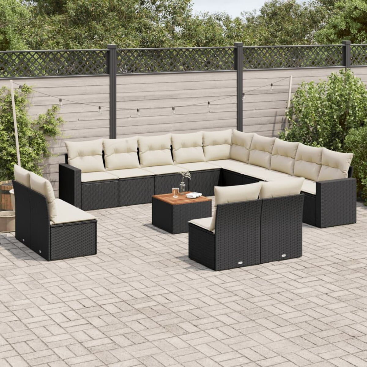 Terrassenset: schwarze Korbmöbel mit beigen Kissen. Enthält einen Couchtisch.