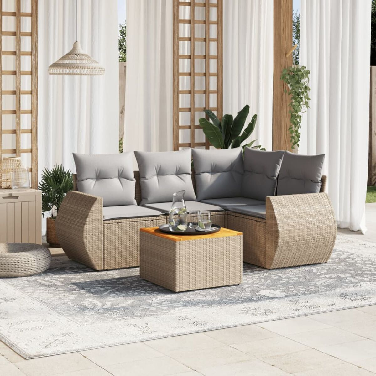 Terrassenmöbel: beiges Korbgeflecht, graue Kissen, Couchtisch, Teppich und Vorhänge.