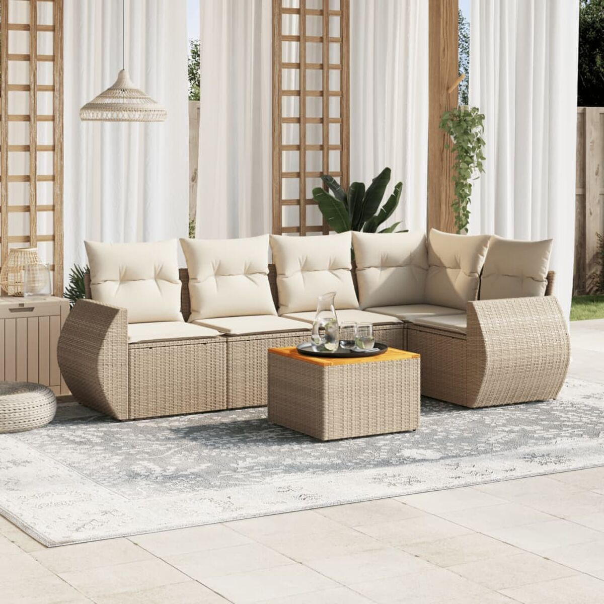 Sitzgelegenheit im Freien mit Sofa, Tisch und Stühlen. Beige Kissen sichtbar.