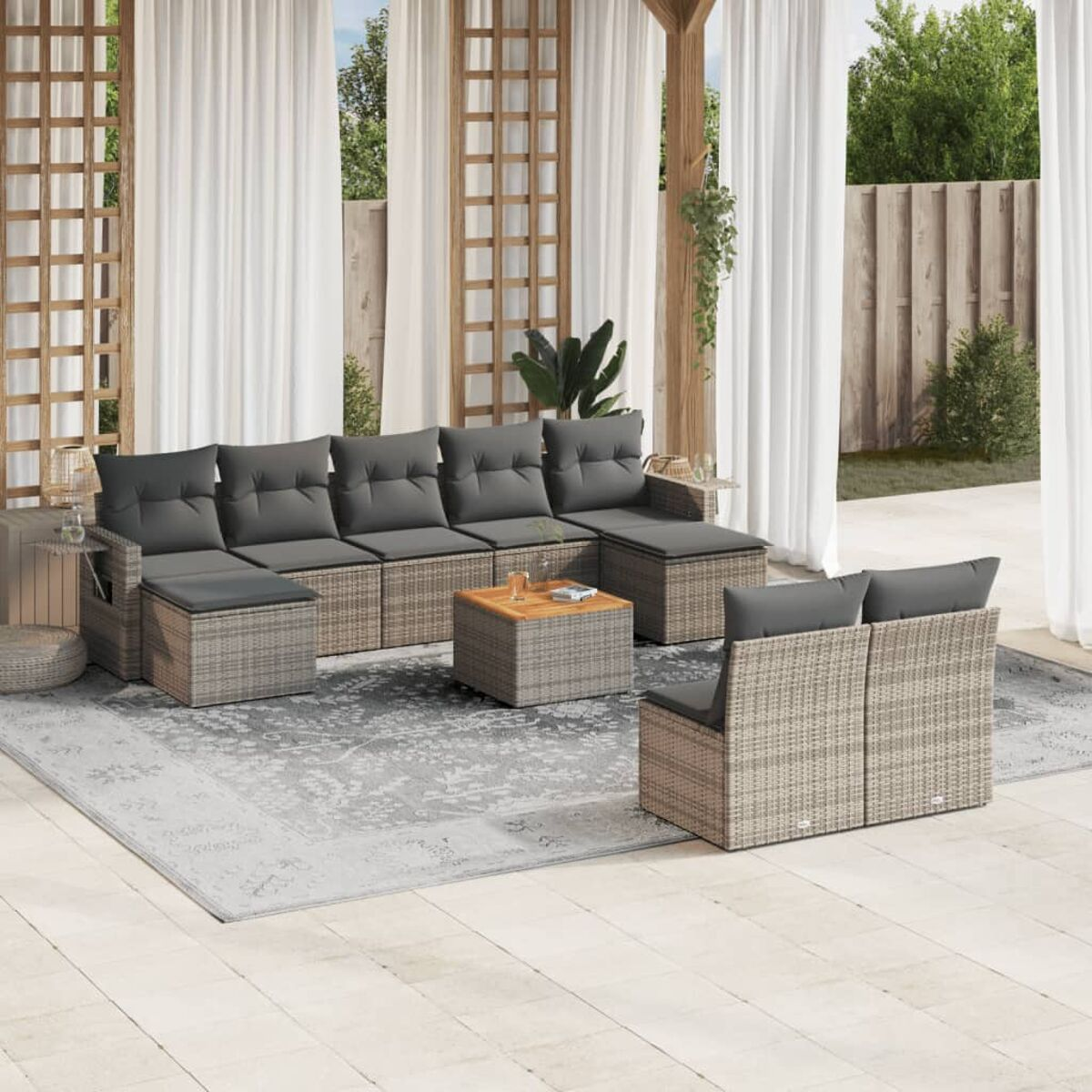 Ecksofa aus Rattan mit grauen Kissen, Couchtisch und Teppich im Außenbereich.
