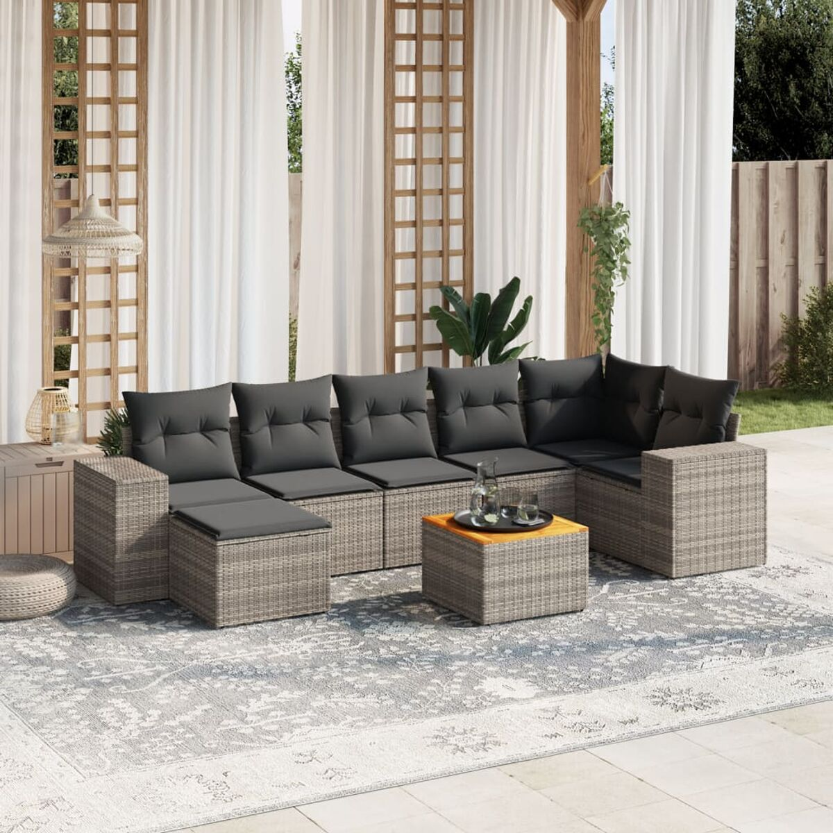 Beiges Outdoor-Sofa-Set aus Korbgeflecht mit grauen Kissen, Tisch und Außenbereich.