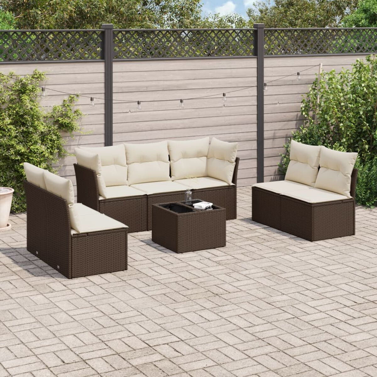 Set di mobili da giardino in rattan marrone, tra cui un divano, due sedie e un tavolino con cuscini beige.