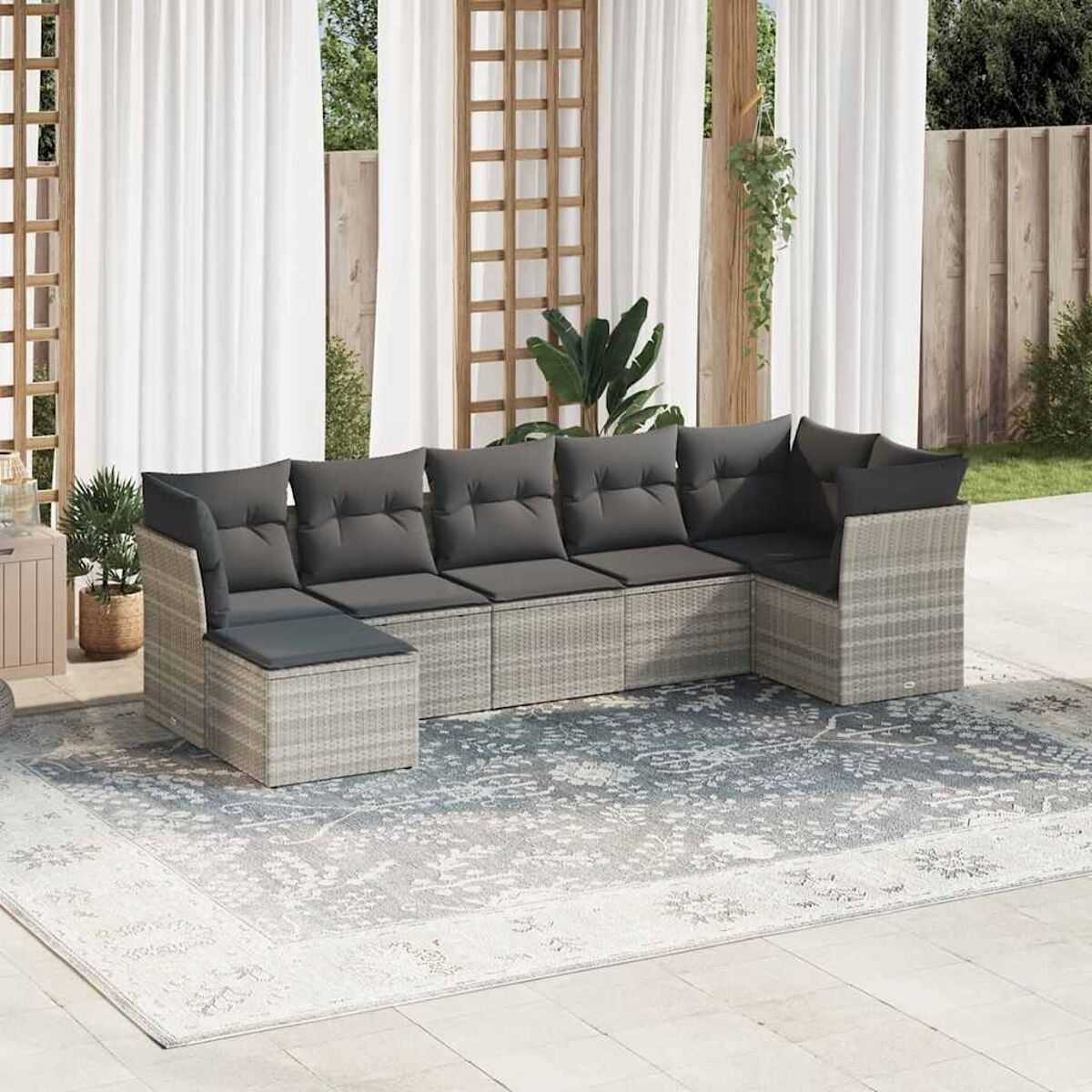Outdoor-Ecksofa-Set mit grauen Kissen. Hintergrund: Terrasse mit Teppich, Vorhängen und Pflanzen.