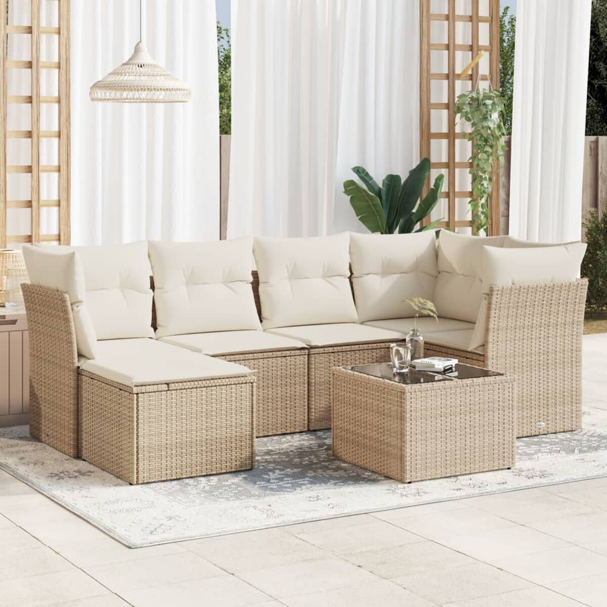 Garten-Set mit beigen Korbmöbeln und Kissen, mit einem Tisch mit Glasplatte.