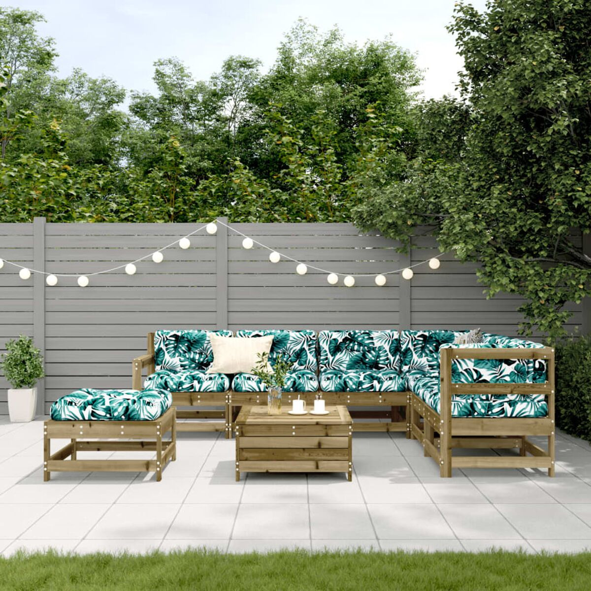 Terrassenset im Freien mit Sofa, Stühlen und Couchtisch. Weißes und grünes Blattmuster auf Kissen.