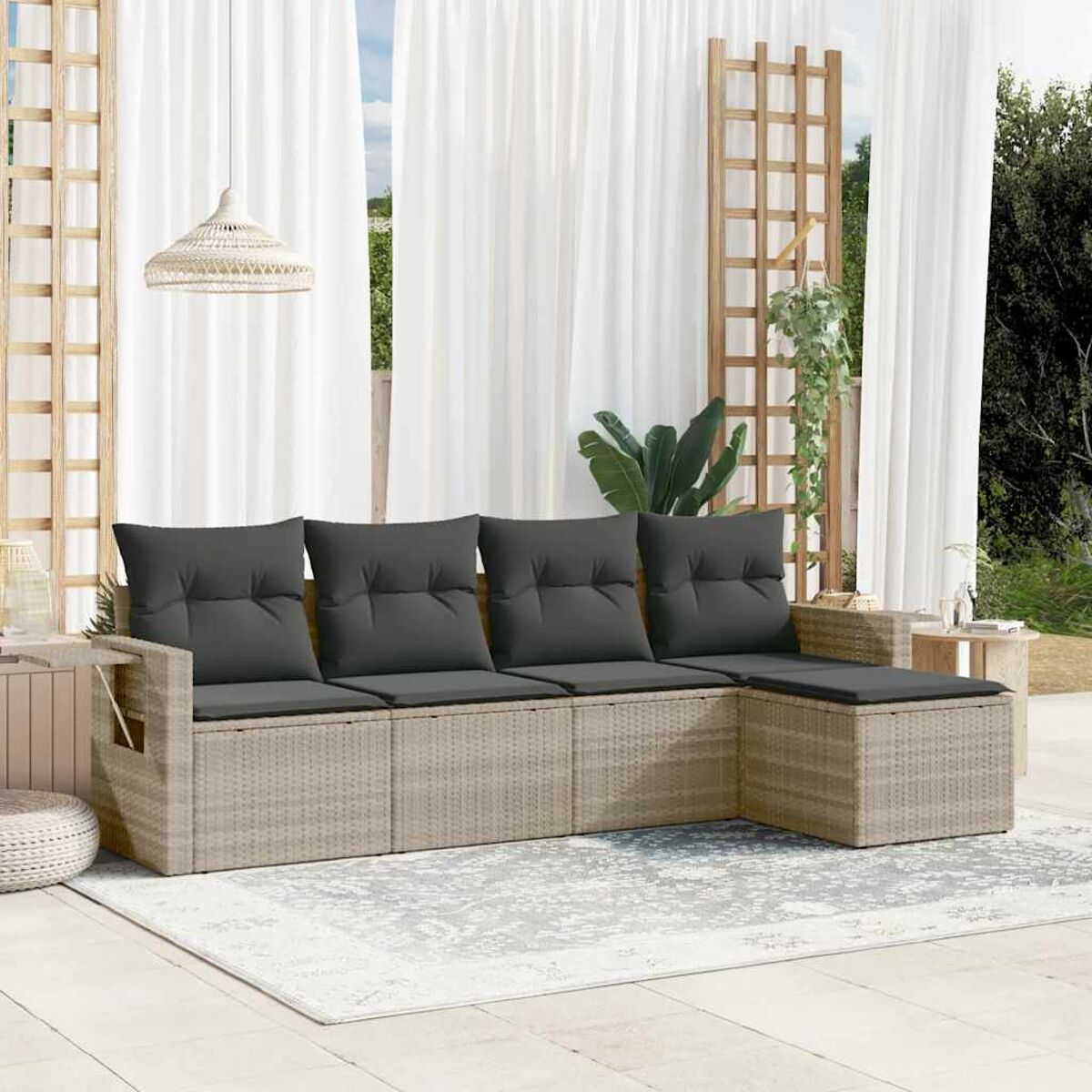 Beiges Korbsessel-Sofa mit grauen Kissen auf einem gemusterten Teppich, im Freien.