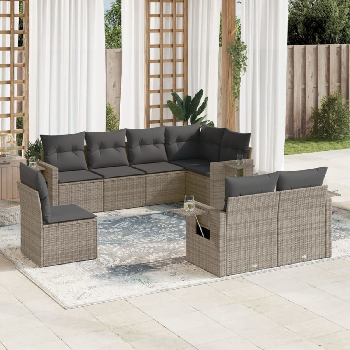 Outdoor-Ecksofa mit grauen Kissen auf einer Terrasse. Hintergrund umfasst Vorhänge und Pflanzen.