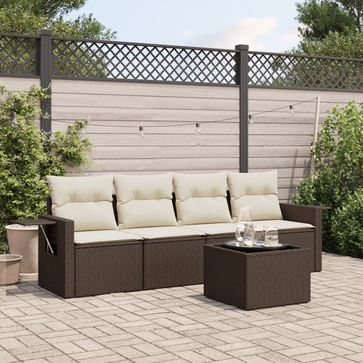 Braunes Outdoor-Sofa-Set aus Korbgeflecht auf einer Terrasse. Enthält Sofa, Beistelltisch und Glastisch.