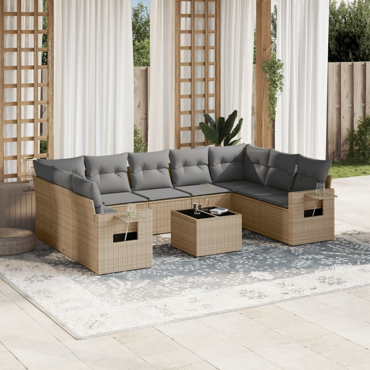 Beiges Rattan-Ecksofa mit grauen Kissen und einem kleinen Tisch auf einer Terrasse.