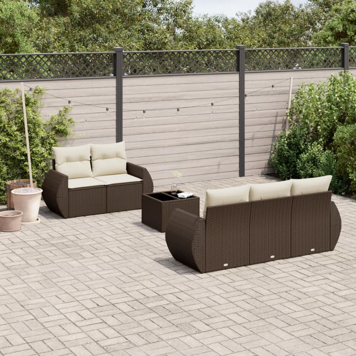 Outdoor-Terrassenmöbel-Set mit braunem Korbgeflecht, beigen Kissen und kleinem Tisch.