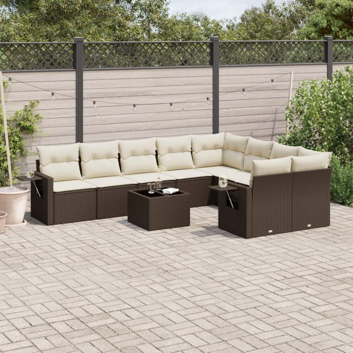 Braunes Outdoor-Ecksofa aus Korbgeflecht mit cremefarbenen Kissen und einem kleinen Couchtisch.