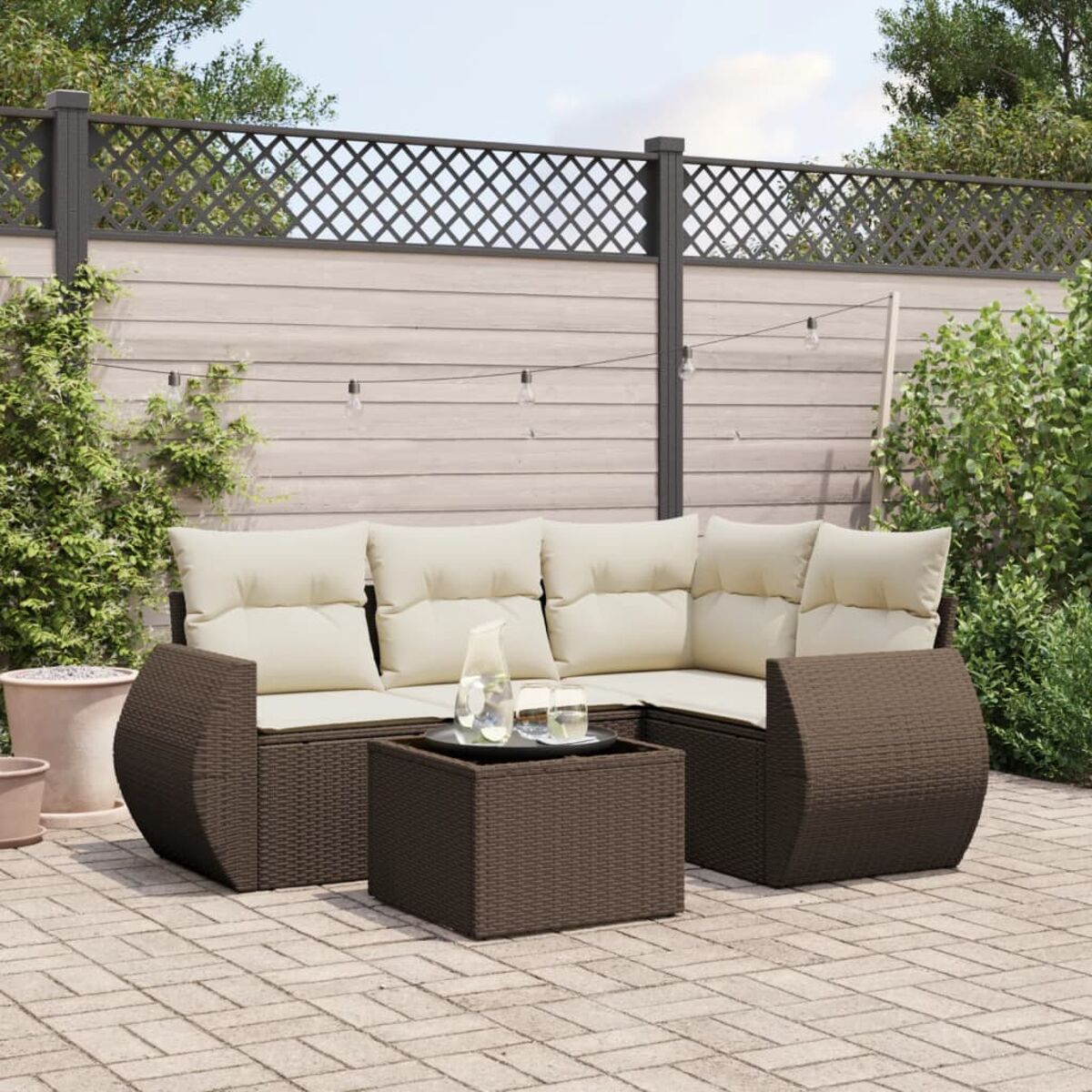 Divano componibile in rattan marrone con cuscini beige e un tavolino quadrato.