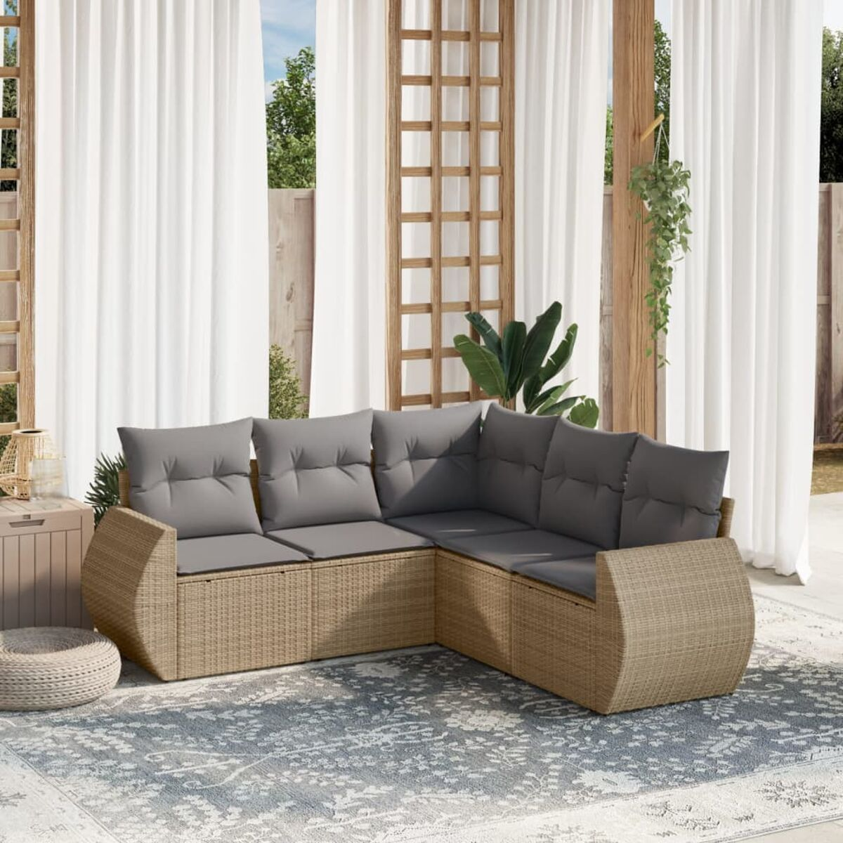 Geflochtenes Ecksofa mit grauen Kissen auf einem Teppich, mit weißen Vorhängen im Hintergrund.