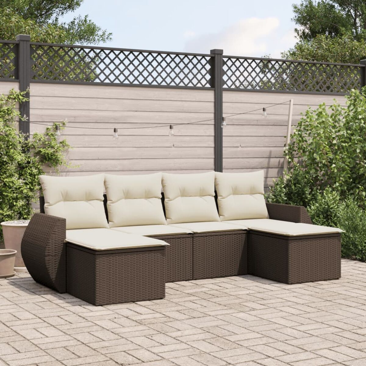 Set divano componibile da esterno in rattan con cuscini beige in un ambiente esterno.