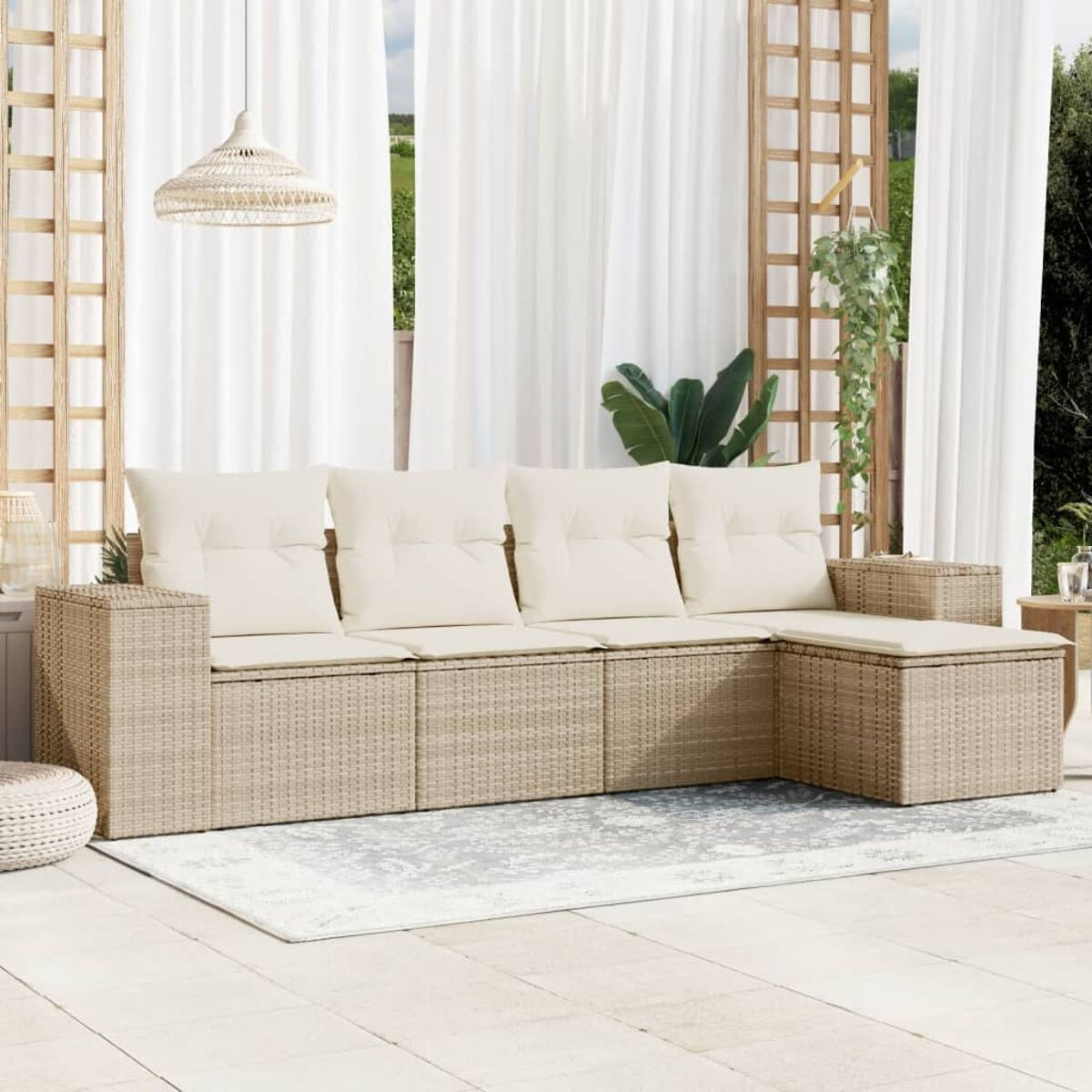 Ein beiges Outdoor-Ecksofa aus Korbgeflecht mit Kissen. Es steht auf einer Terrasse mit Vorhängen.