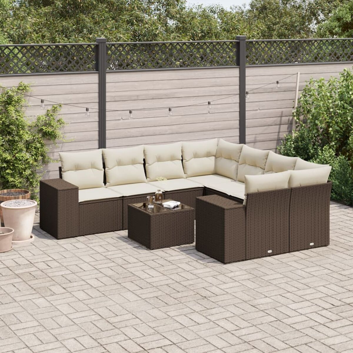Braunes Korbssofa-Set mit beigen Kissen und einem Couchtisch. Outdoor-Setting.