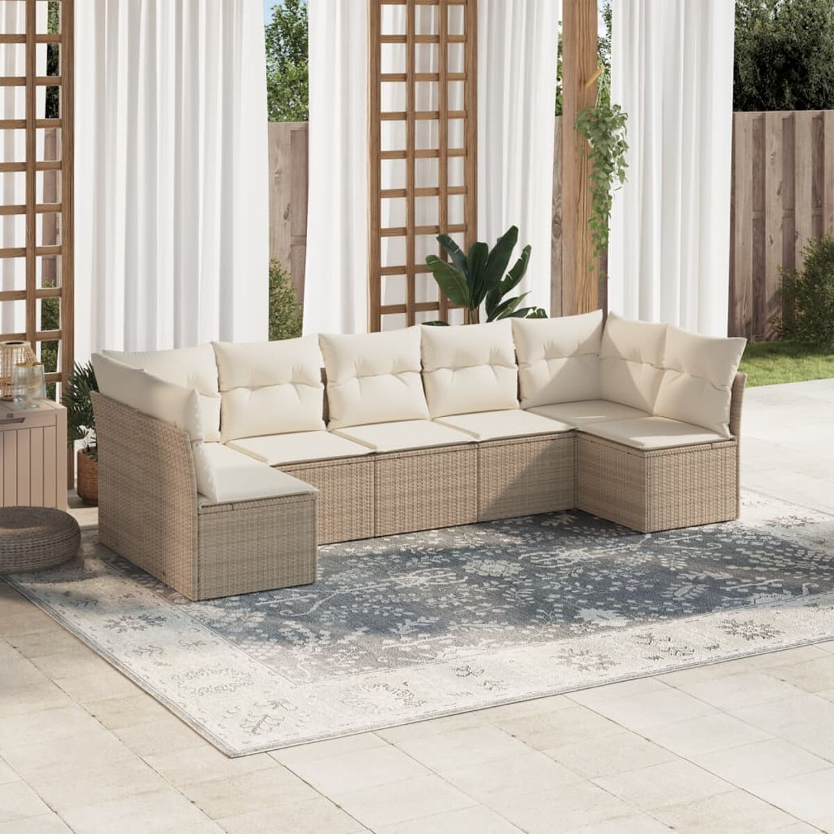 Rattan-Ecksofa mit beigen Kissen auf grauem Teppich, Terrasse.