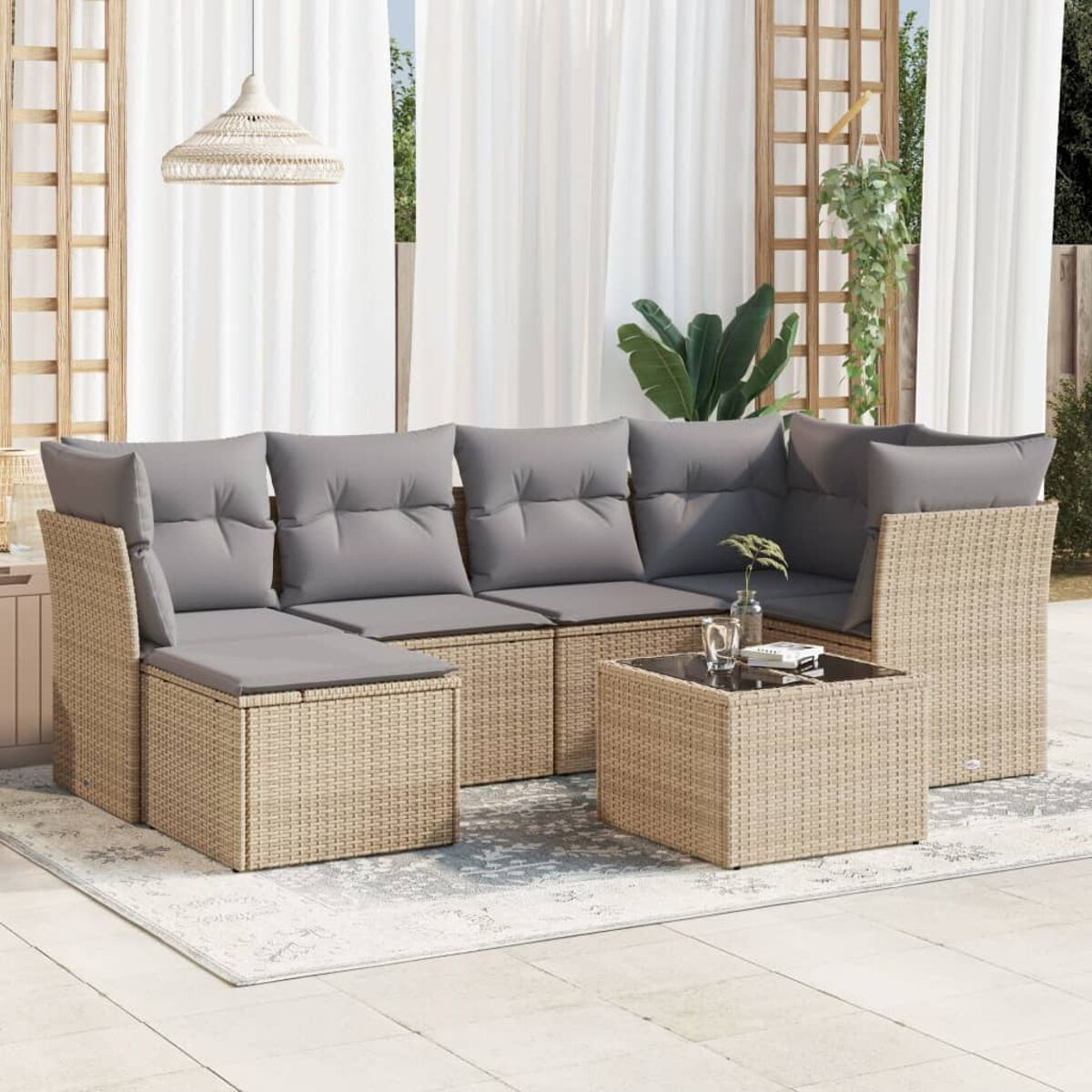 Ecksofa aus Korbgeflecht mit grauen Kissen und einem Tisch mit Glasplatte.