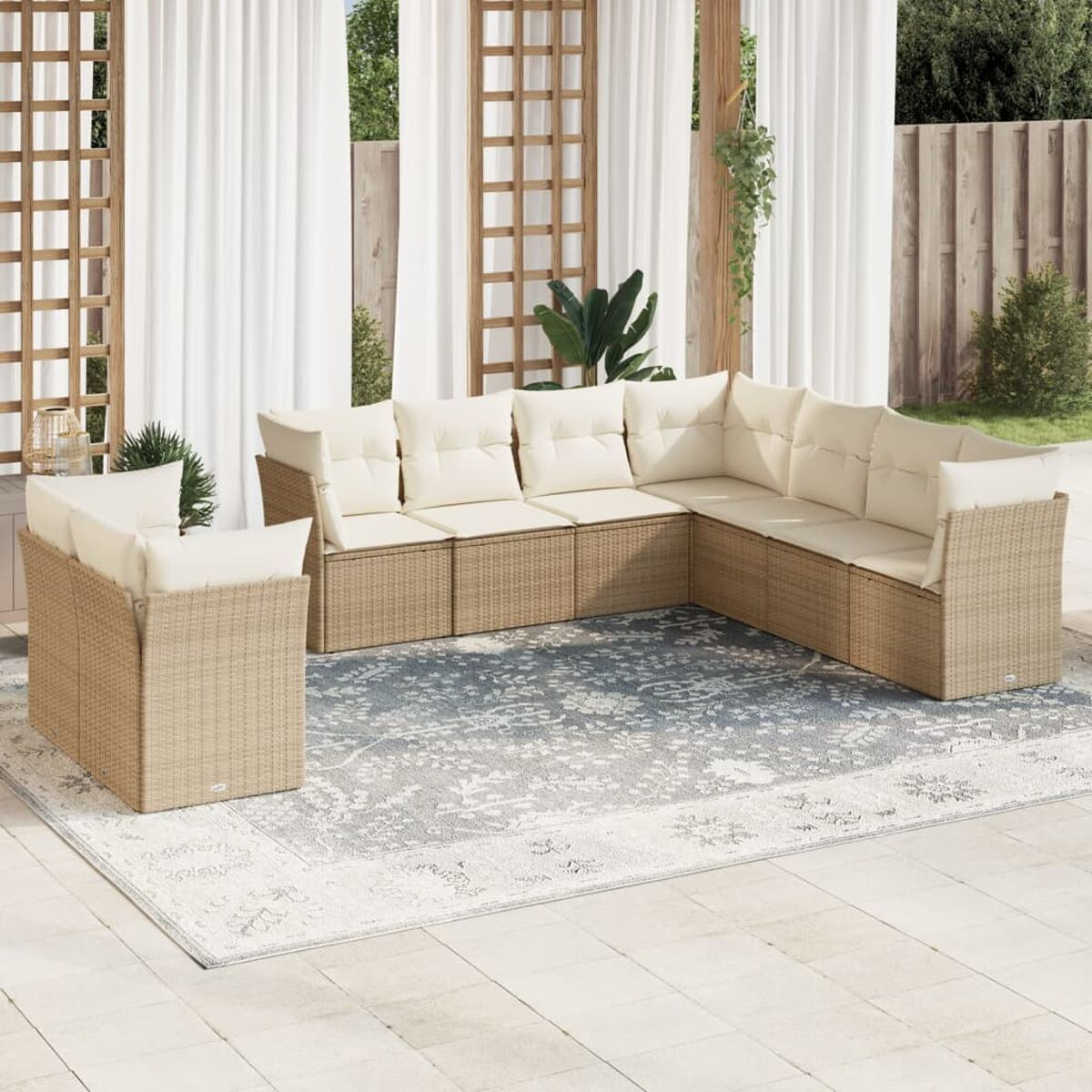 Outdoor-Sitzgruppe. Beiges Sofa aus Weide mit cremefarbenen Kissen. Weiße Vorhänge und Teppich.