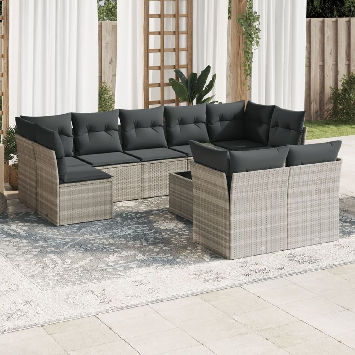 Set patio esterno, vimini marrone chiaro con cuscini grigi, disposto su un patio con tappeto.