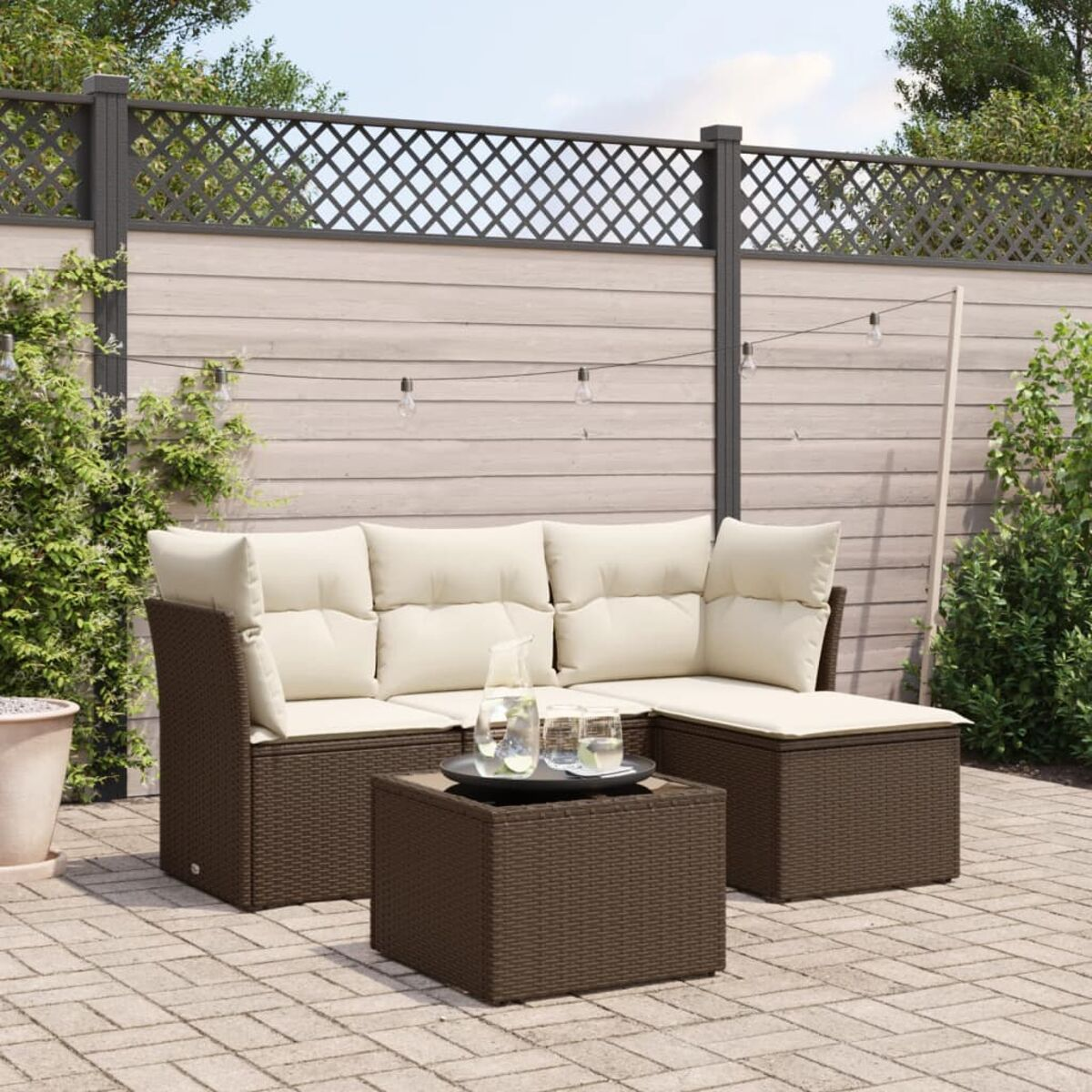 Braunes Rattan-Outdoor-Sofaset mit beigen Kissen, Couchtisch und einer Terrasse.