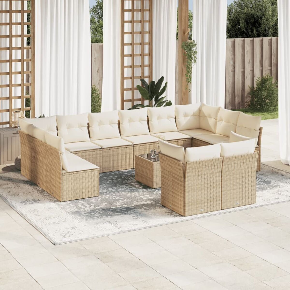 Rattan-Außensofa-Set mit cremefarbenen Kissen und quadratischem Tisch. Auf einem gemusterten Teppich.