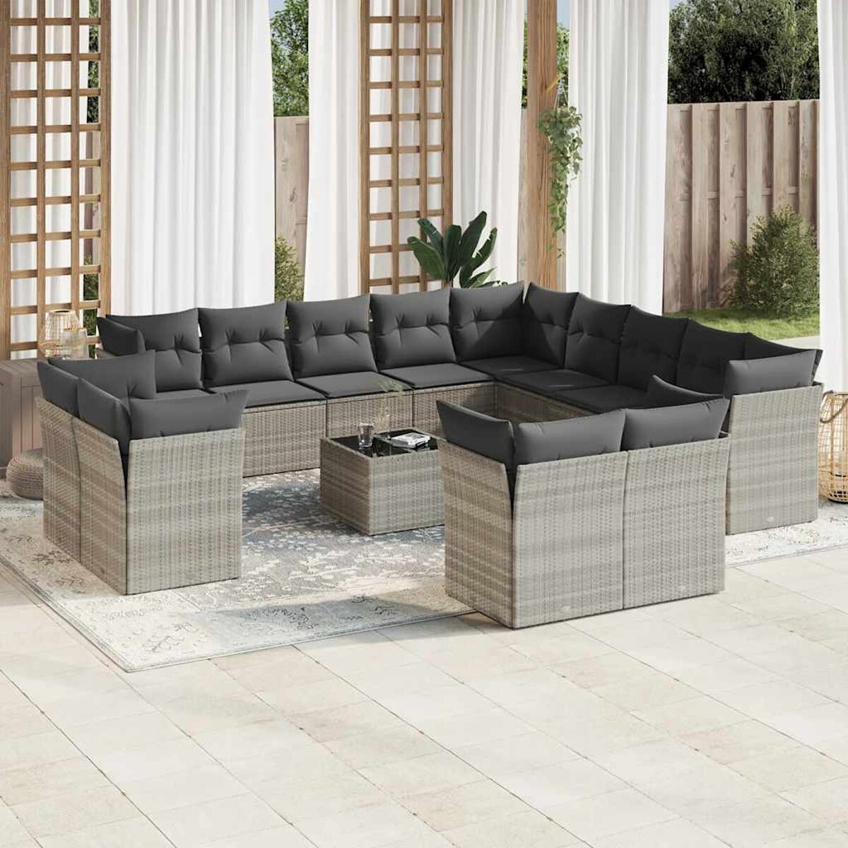 Geflochtenes Outdoor-Ecksofa-Set mit grauen Kissen auf einer Terrasse.