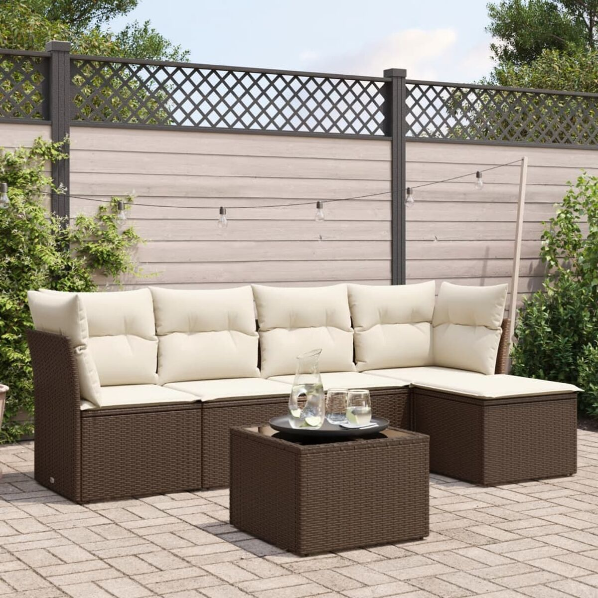 Set di mobili da esterno con design in vimini marrone. Include un divano, un tavolino e un tavolino con bicchieri.