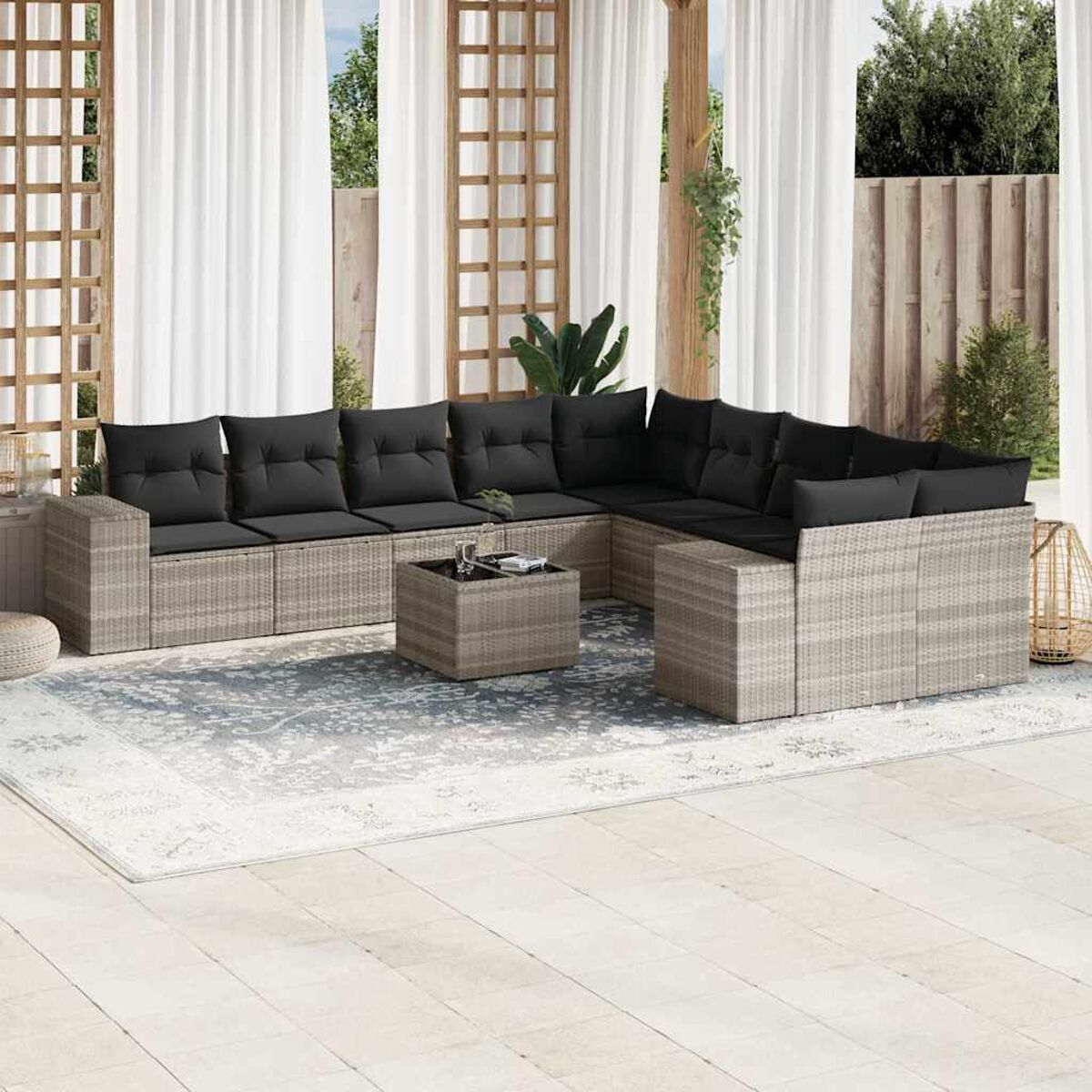 Outdoor-Terrassenset mit grauen Korbmöbeln und schwarzen Kissen.