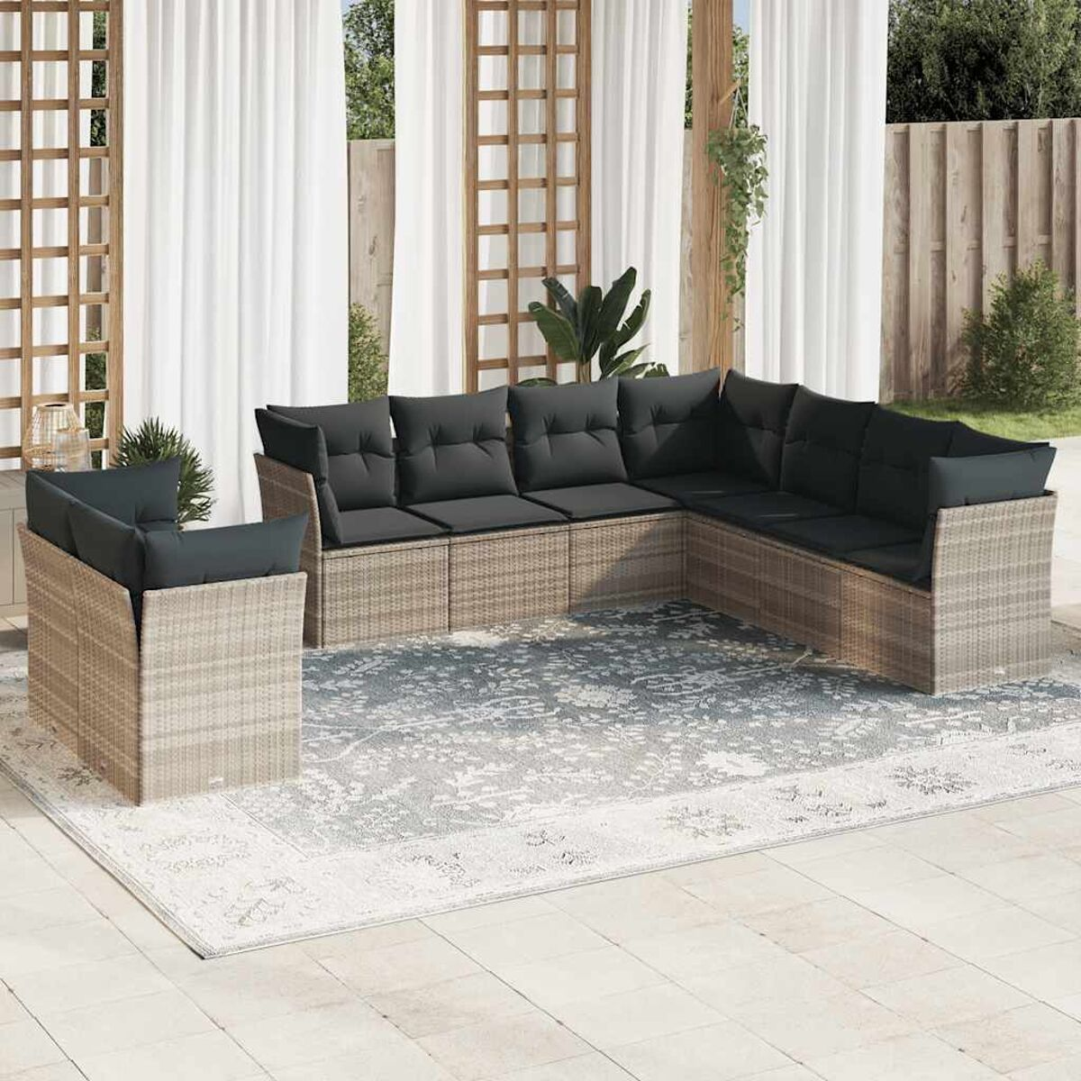 Beiges Rattan-Outdoor-Sofaset mit grauen Kissen. Terrasse, weiße Vorhänge, Holzrahmen, Pflanzen.
