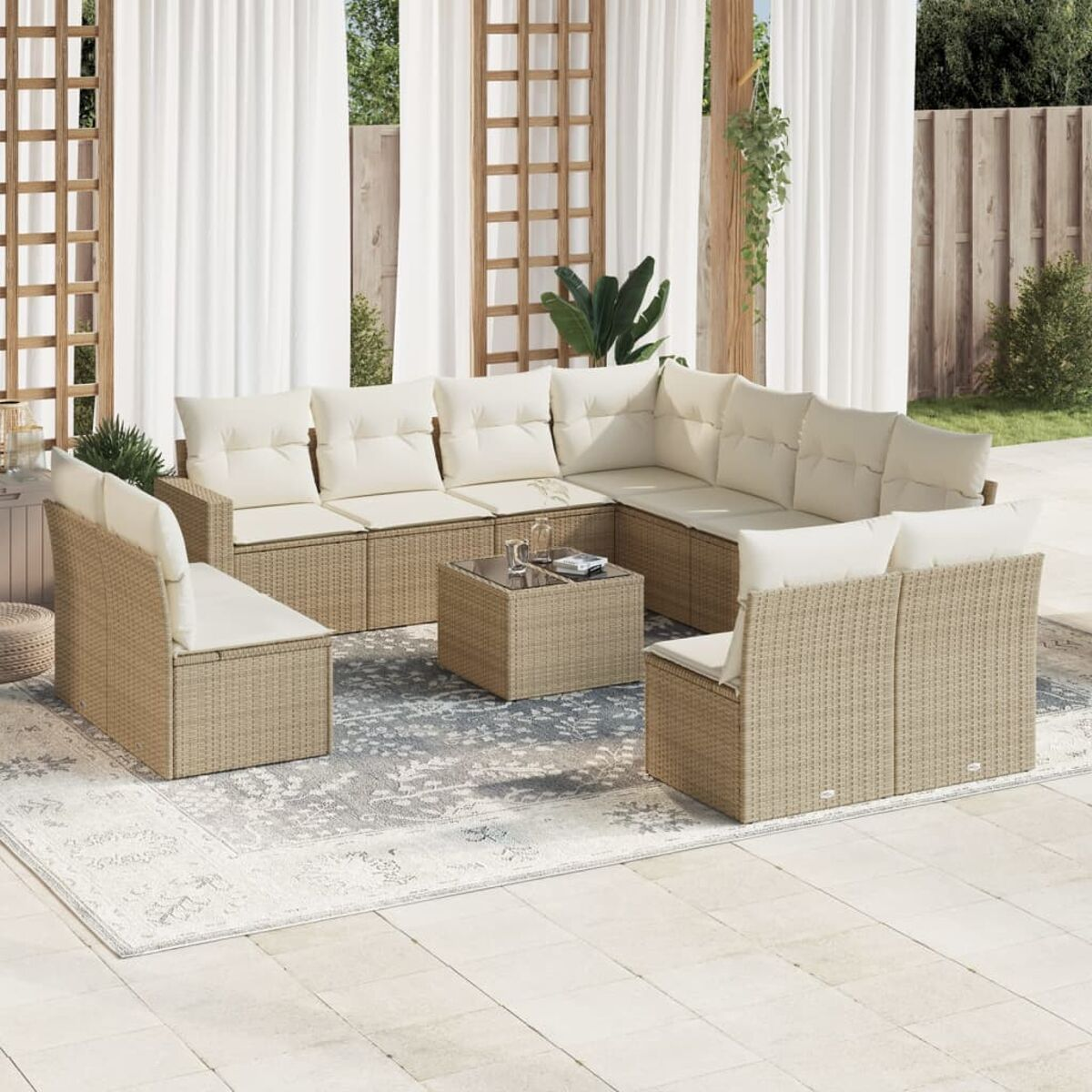 Terrassengarnitur mit Korbmöbeln, Kissen und einem Teppich. Inklusive Couchtisch. Sonniger Außenbereich.