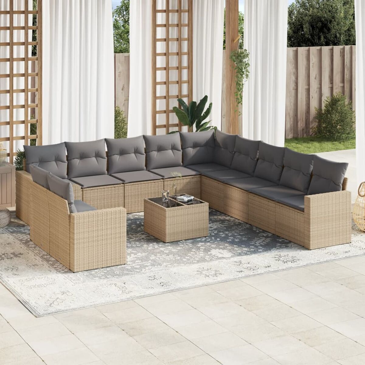 Outdoor-Geflecht-Ecksofa mit grauen Kissen und einem Couchtisch. Weiße Vorhänge, Pflanzen.