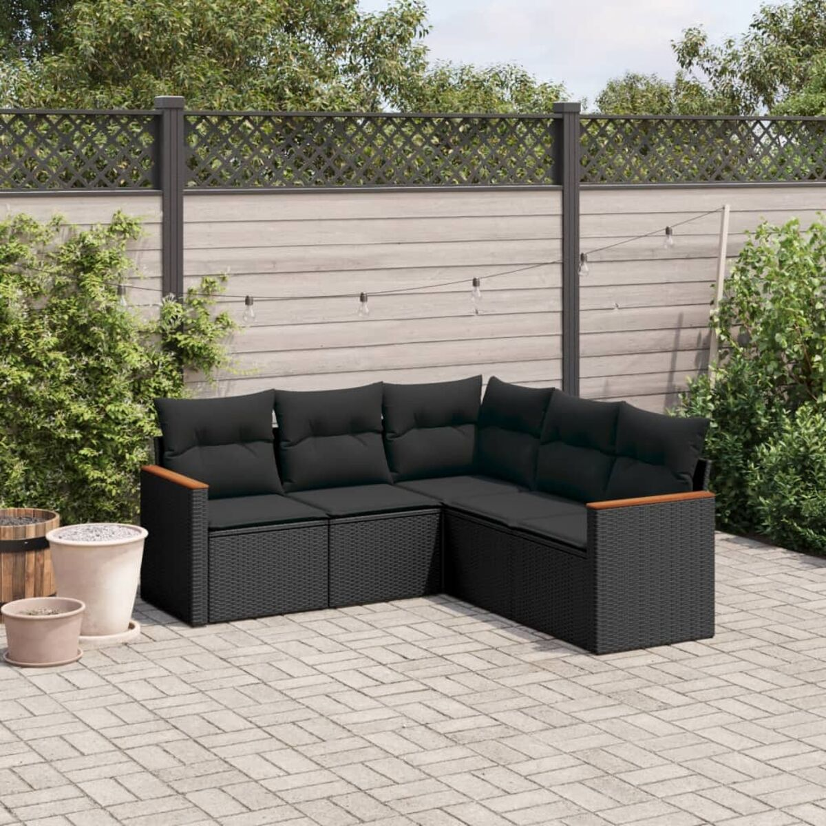 Schwarzes Outdoor-Ecksofa mit Holzarmlehnen, schwarzen Kissen, auf einer Terrasse.