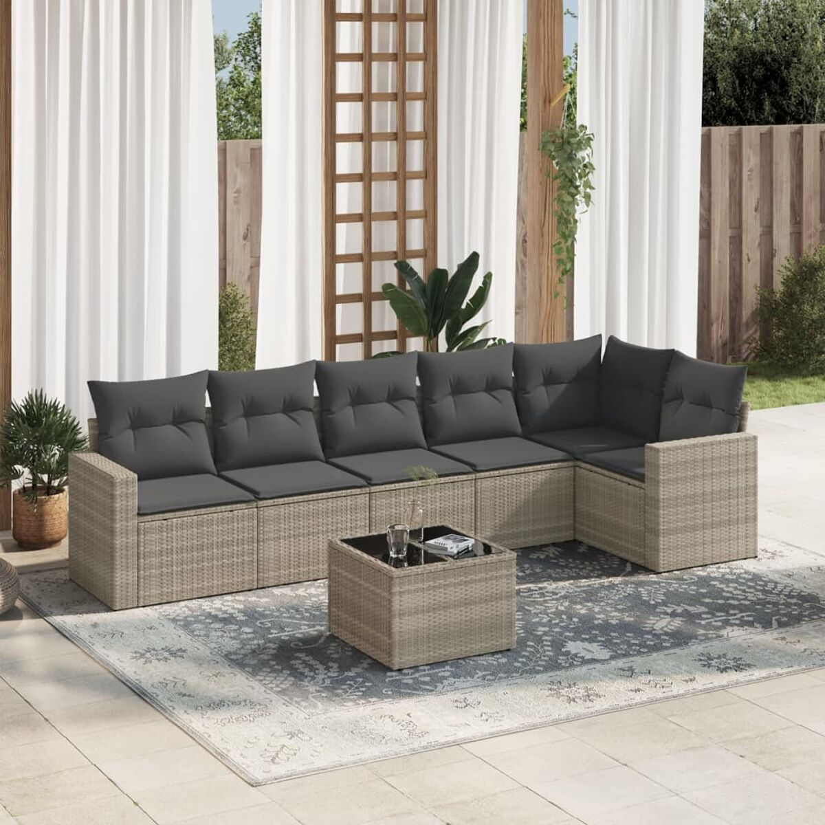 Beiges Eck-Outdoor-Sofa mit grauen Kissen und Couchtisch auf einem Teppich. Vorhänge sichtbar.