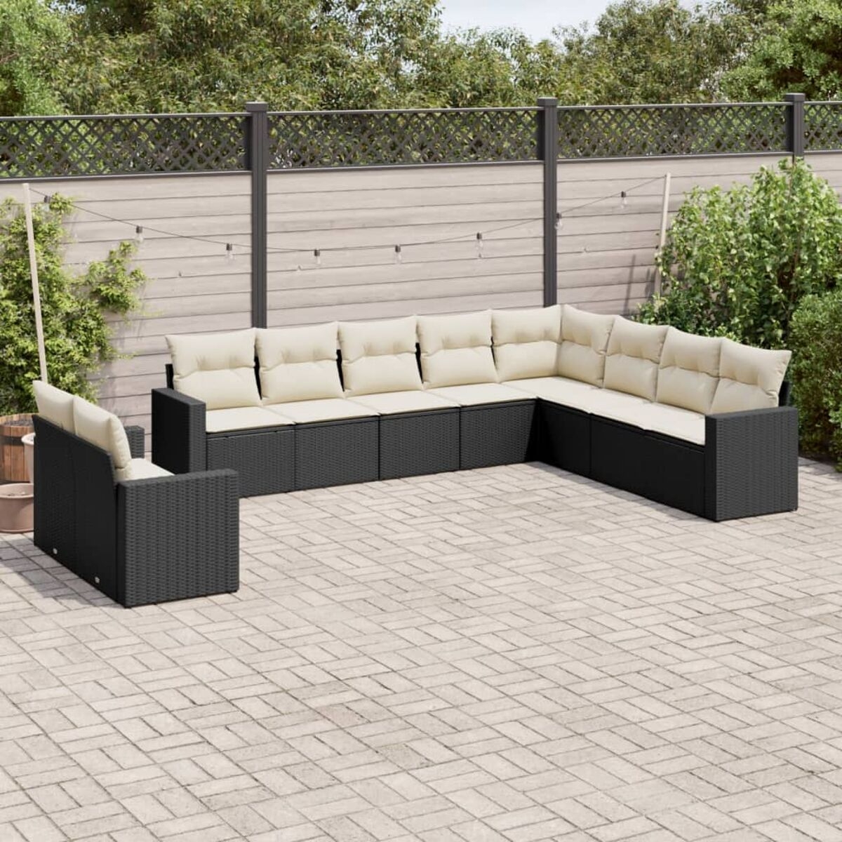Schwarzes Outdoor-Ecksofa aus Korbgeflecht mit beigen Kissen.