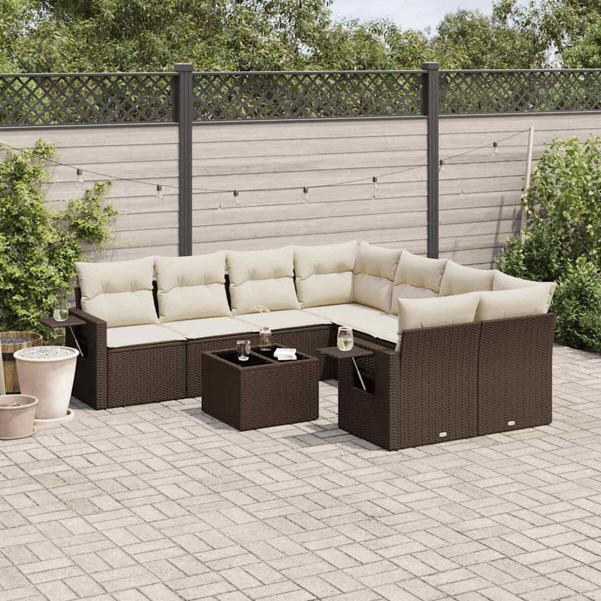 Set di mobili in rattan da esterno con cuscini beige e un tavolino. Include un divano e una poltrona.