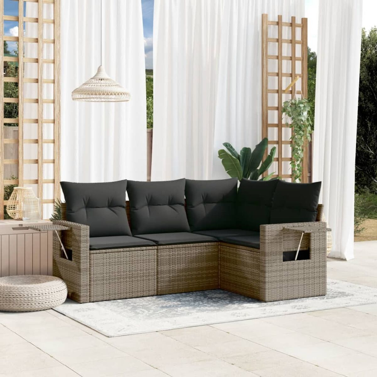 Outdoor-Ecksofa mit schwarzen Kissen. Kleiner Tisch, Teppich und weiße Vorhänge im Hintergrund.