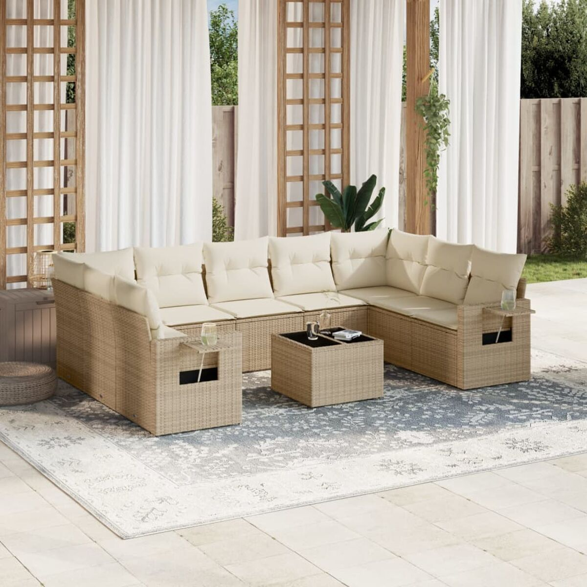 Garten-Rattansofa-Set mit Kissen und kleinem Tisch auf einem gemusterten Teppich.