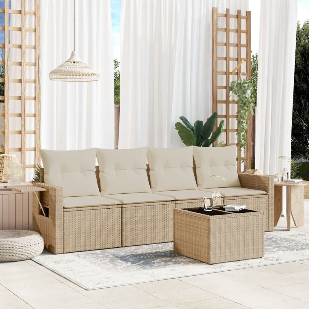 Rattansofa mit cremefarbenen Kissen und kleinem Tisch im Freien, transparente Vorhänge.