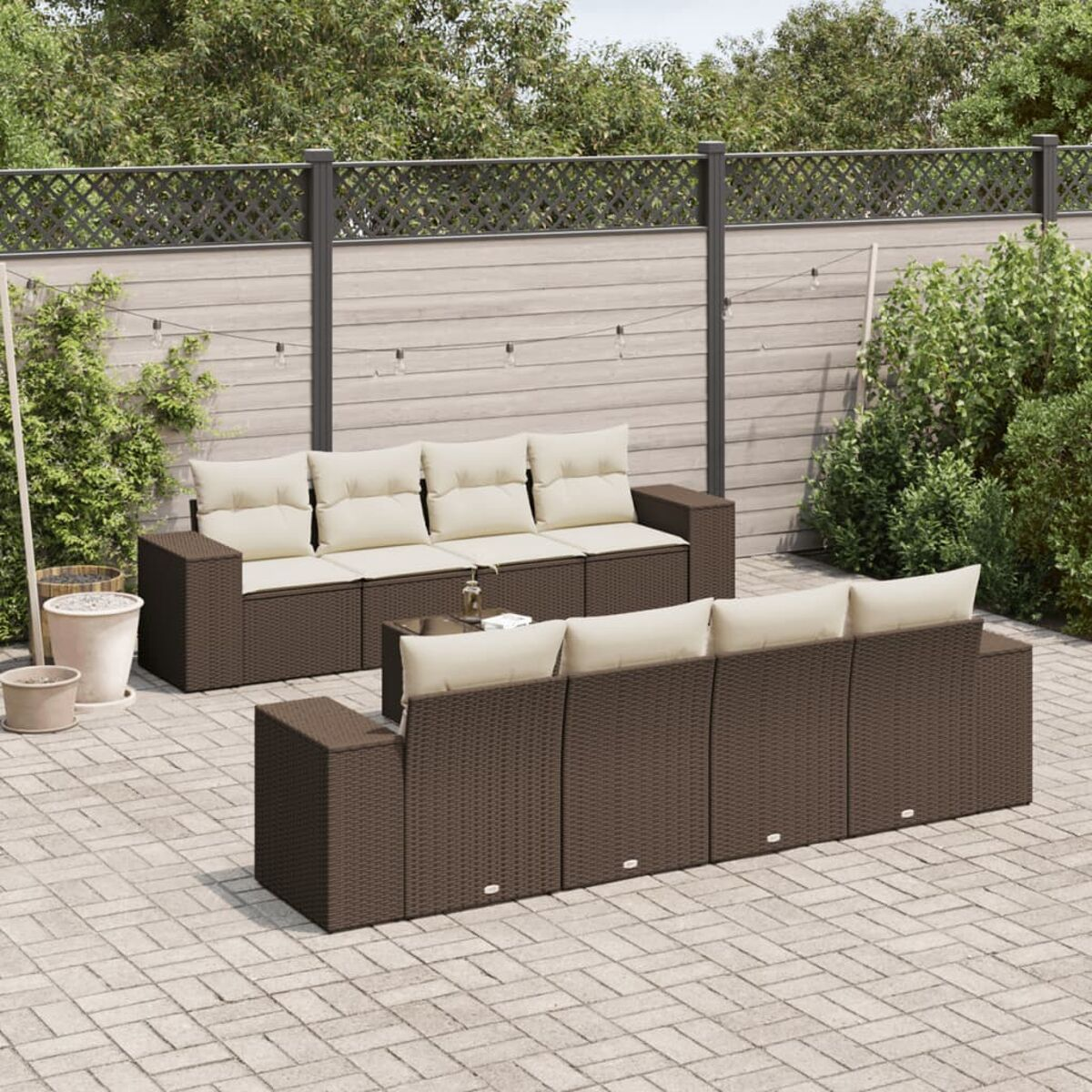 Divano angolare in rattan marrone con cuscini color crema, su patio, esterno.