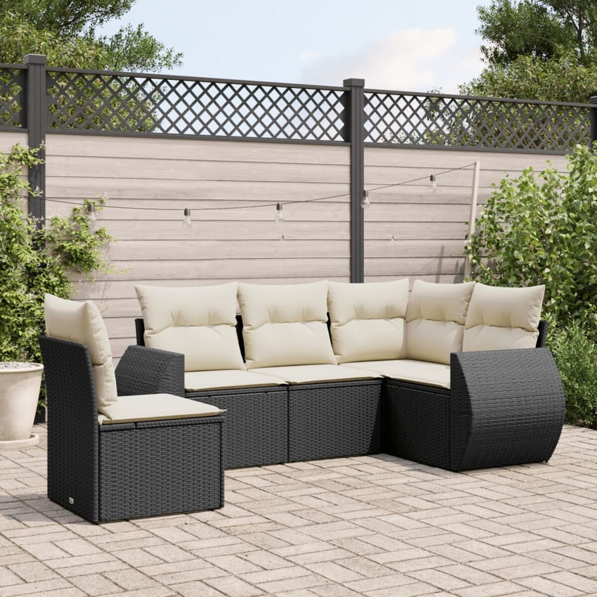 Schwarzes Outdoor-Sofa-Set aus Korbgeflecht mit cremefarbenen Kissen und passendem Stuhl.