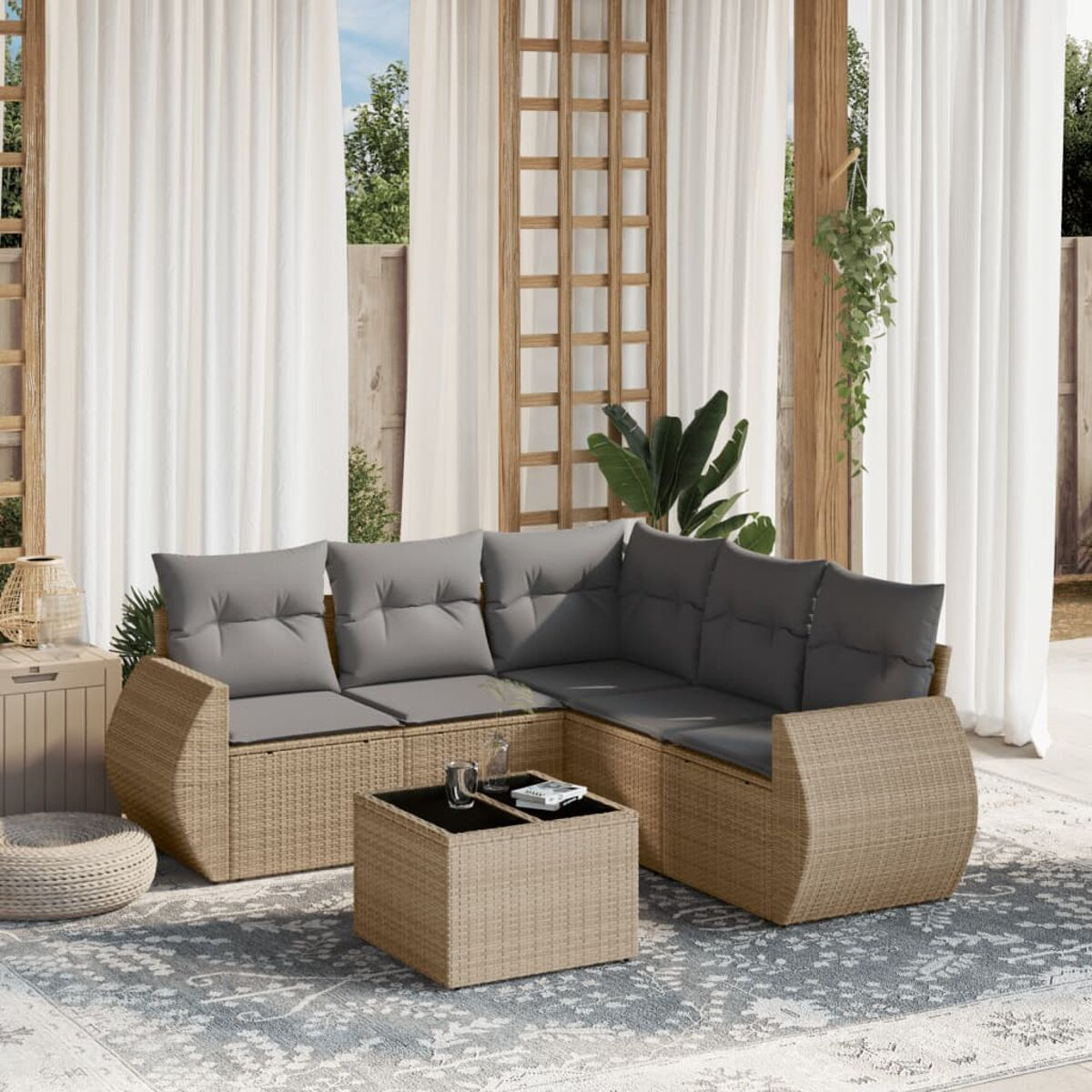 Outdoor-Wicker-Ecksofa mit grauen Kissen, Couchtisch auf einer Terrasse. Weiße Vorhänge, natürliches Licht.