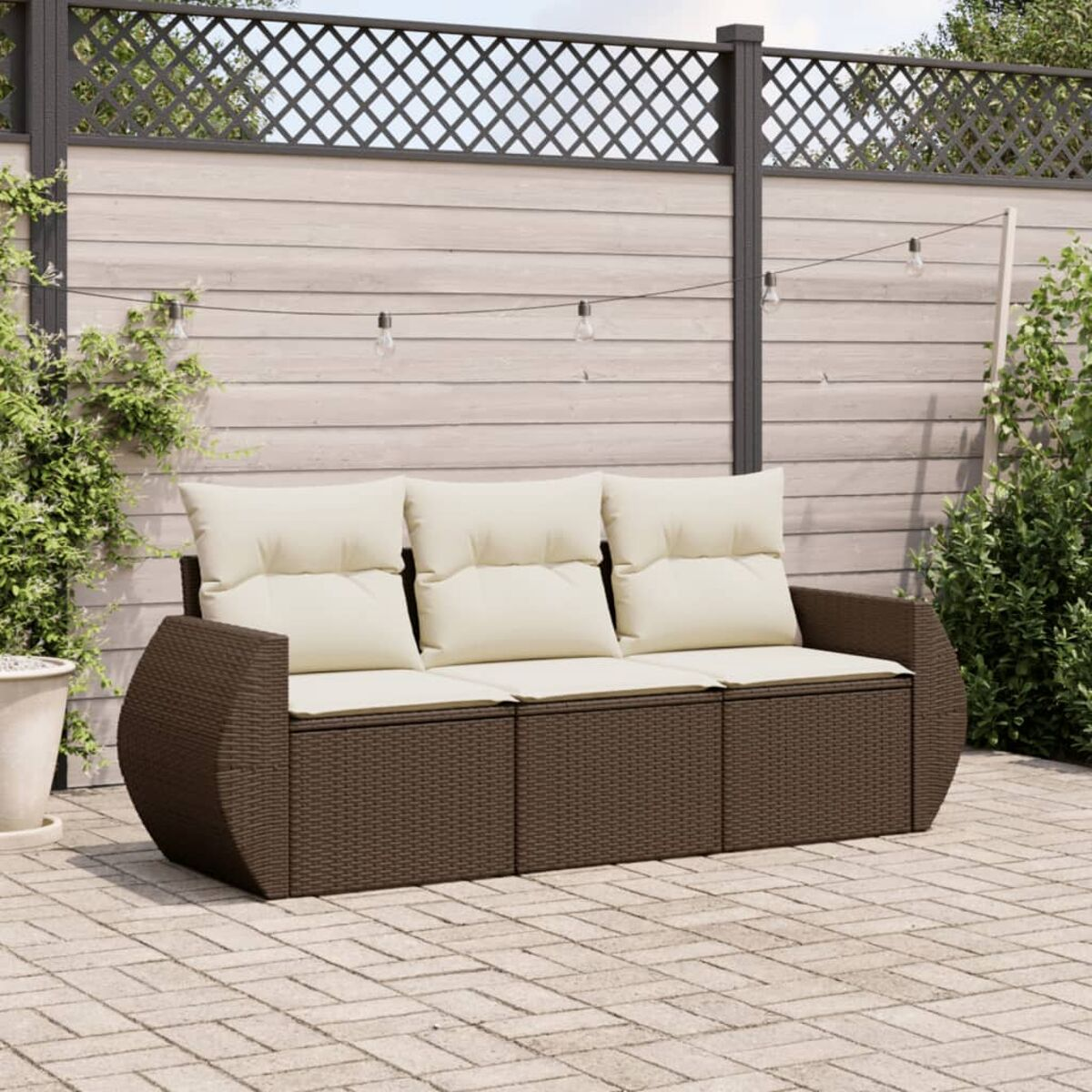 Divano da esterno in rattan marrone con cuscini beige su un patio. Presenta un design curvo.