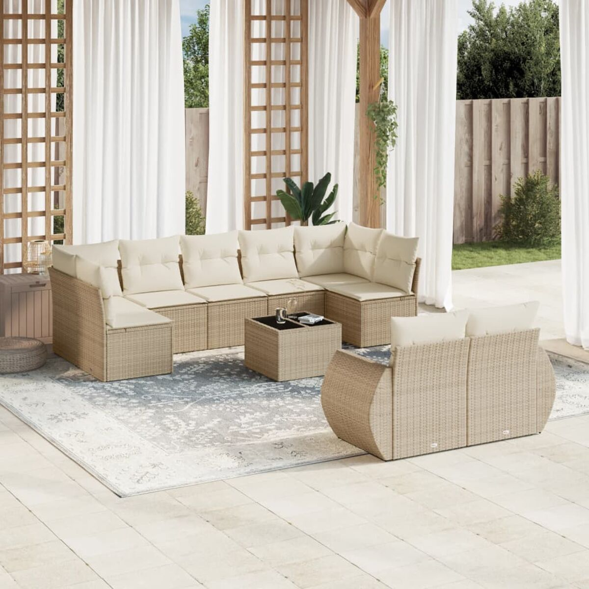 Beiges Rattan-Ecksofa mit cremefarbenen Kissen, Couchtisch und Teppich auf einer Terrasse.