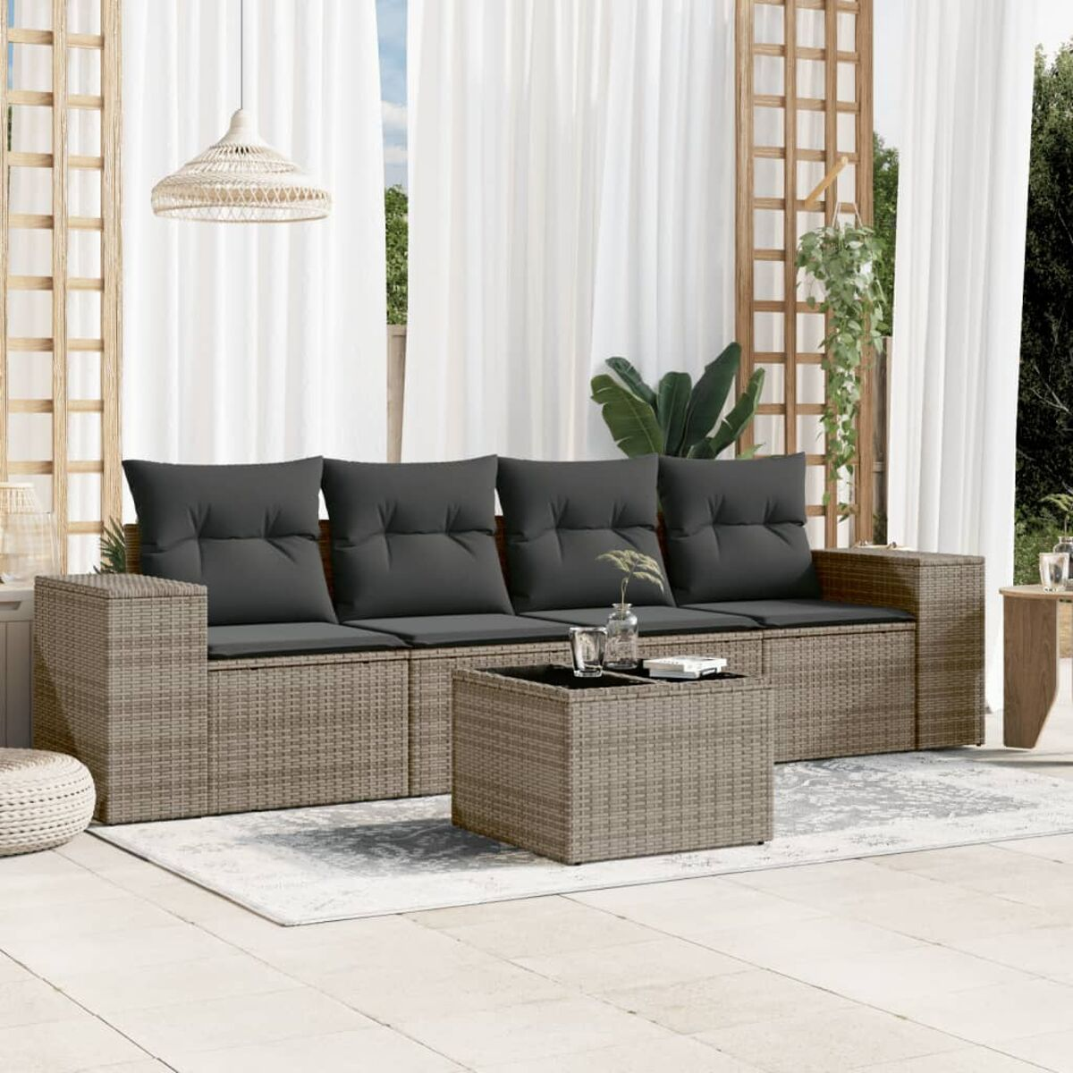 Ecksofa aus Korbgeflecht mit grauen Kissen und einem Couchtisch auf einem Teppich, Vorhänge.